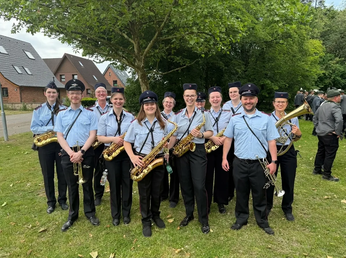 Musiker:innen des Musikzugs in blauer Uniform mit Saxophonen, Trompeten und Tenorhorn bei einem Auftritt